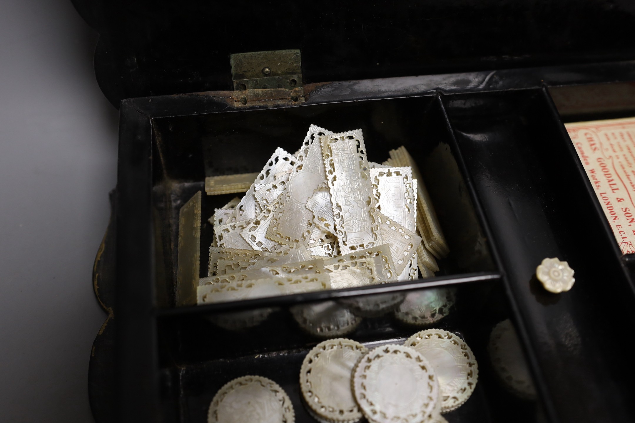 A Victorian papier-mâché games box with mother of pearl inlay and mother-of-pearl counters